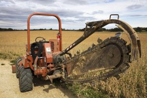 Old,style,trenching,machine,in,the,field.